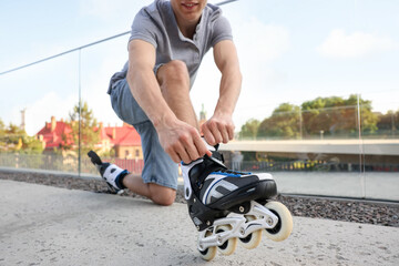 Man putting on roller skates outdoors, closeup