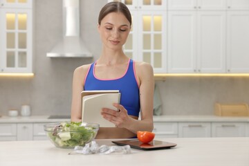 Woman developing diet plan at white table indoors
