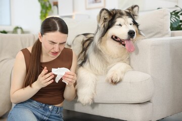 Woman suffering from allergy with her dog at home