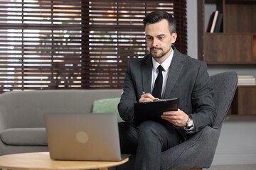 Professional psychologist having online consultation with his client via laptop indoors. Space for...