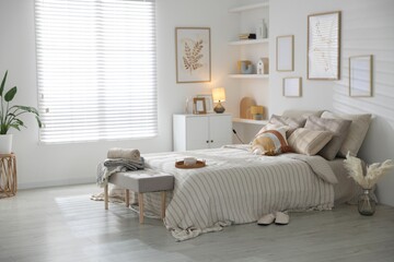 Comfortable bed with soft linens in room. Home textile