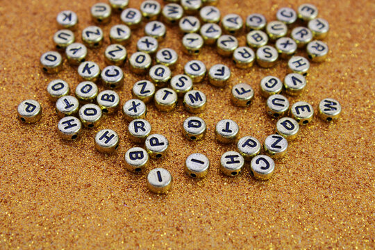 Beads for making necklaces and bracelets with letters on a gold background - Powered by Adobe