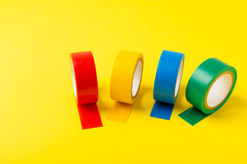 Insulating tape on a bright colored background. Set of different colors insulating tape. Reel...