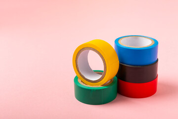 Insulating tape on a bright colored background. Set of different colors insulating tape. Reel...
