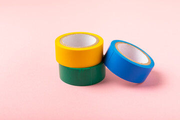 Insulating tape on a bright colored background. Set of different colors insulating tape. Reel...
