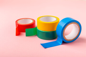 Insulating tape on a bright colored background. Set of different colors insulating tape. Reel...