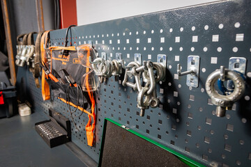 Pegboard organizing lifting equipment and safety gear in workshop