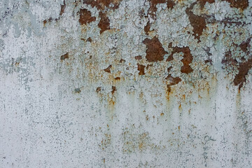 Background with an image of an old iron wall painted with light paint. The surface is cracked, with...