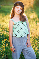 Portrait of adorable preschool caucasian kid 8-9 years old standing in park over blurred background...