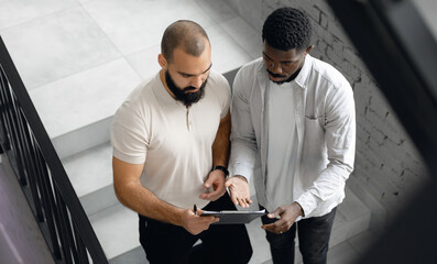 Collaborative African American and Caucasian Business Team Reviewing Tablet Information