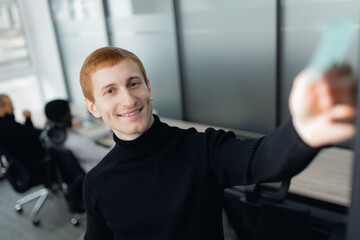 Caucasian Professional Taking Selfie in Modern Office Environment