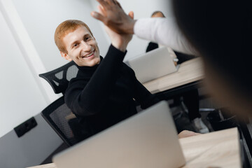 Celebrating Success in Modern Office with High Five Gesture Among Team Members
