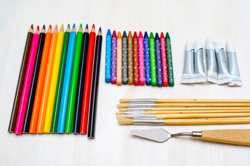 Watercolor oil paints, paintbrushes, colorful pencils, pastel crayons,watercolor paper pad. Creativity creation. Artist's stuff.drawing supplies