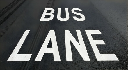 Designated Bus Lane Signage Painted On Asphalt Road Surface With Tire Marks