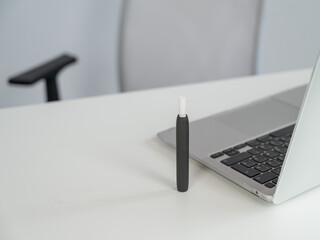 Tobacco heating system next to a laptop. 