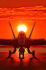 Silhouette of a jet fighter at sunset.