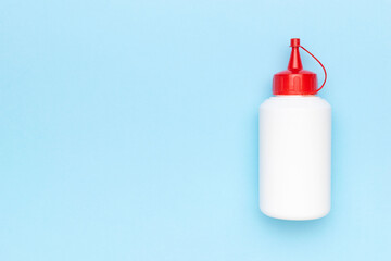 Minimalist White Squeeze Bottle with Red Cap on Light Blue Background