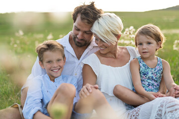 Young family enjoying peaceful summer evening outdoors in green summer nature