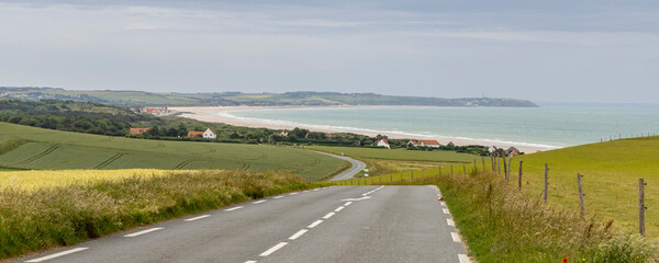 Road along Opal coast with sea view and little village with white houses in Northern France