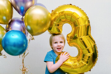 Cute happy child kid boy celebrating birthday with colorful balloons at party,home.baby smiling looking at camera.adorable caucasian baby.Festive background decoration