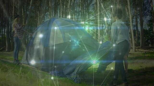 Friends entering clearing carrying tent assembling campsite with animated overlay for camping demo