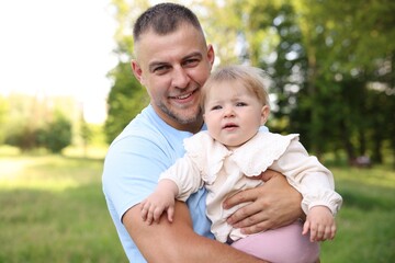 Fototapeta premium Smiling dad and his newborn baby outdoors. Happy Father's Day