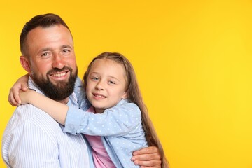 Fototapeta premium Family. Happy father and his daughter on yellow background. Space for text
