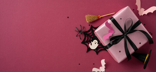 Halloween-themed pink gift box with decorations including bats, a broomstick, spider web, and stars