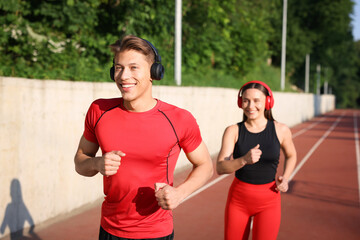 Sporty couple running at stadium, selective focus