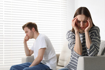 Woman and man having quarrel on sofa at home, selective focus