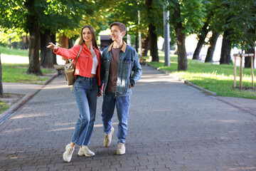 Obraz premium Lovely couple walking together in park, space for text