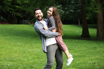 Family getaway. Happy father and daughter having fun in park