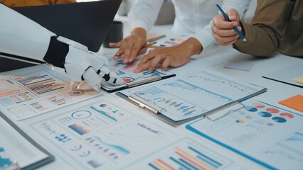 A collaborative office scene featuring human hands working alongside a robotic arm, highlighting...