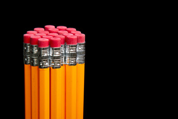 A stack of pencils with red erasers on top