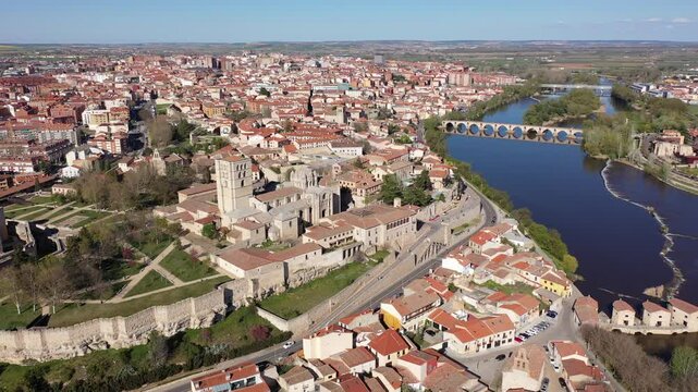 Scenic drone view of ancient walled Spanish city of Zamora on bank of Duero River overlooking Romanesque medieval cathedral on sunny spring day. High quality 4k footage