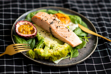 Salmon fish steak grilled, avocado and fresh vegetable salad. Ketogenic diet. Low carb high fat breakfast. Healthy food concept.