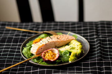 Salmon fish steak grilled, avocado and fresh vegetable salad. Ketogenic diet. Low carb high fat breakfast. Healthy food concept.