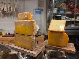 Gourmet cheese selection arrangement in artisan shop interior. Bar in Spain. World Cheese Day. Close-up. Spanish cheese