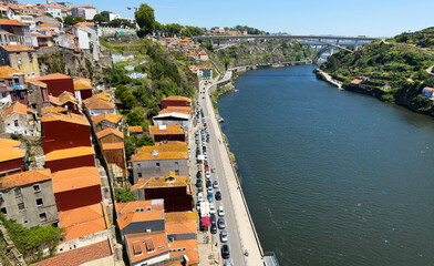 Porto waterfront landscape with Douro River, traditional red roof houses, colorful hillside