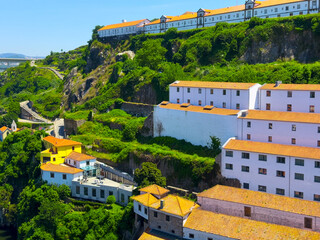 Scenic hillside cityscape of Porto, Portugal with traditional orange rooftops, green nature, bright