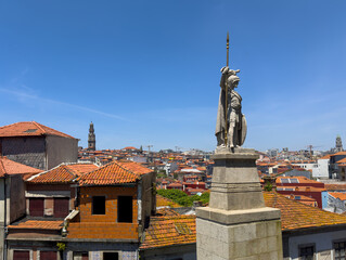 Obraz premium Statue in Porto, Portugal, medieval warrior with spear overlooking cityscape, red tiled rooftops,