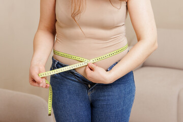 Woman Measuring Waist for Weight Loss Diet and Body Transformation Concept Close Up of Tape Measure