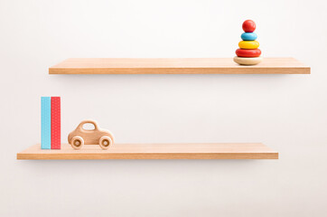 two wall shelves with children's toys and books with empty space for product presentation