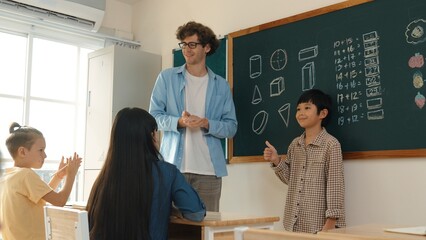 Student standing at in front of class and start to introduce himself at classroom while caucasian...