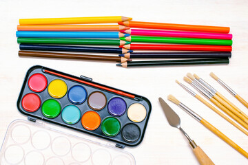 Watercolor oil paints, paintbrushes, colorful pencils, pastel crayons,watercolor paper pad. Creativity creation. Artist's stuff.drawing supplies