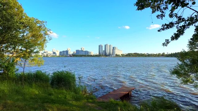 City near lake at sunset. Downtown Minsk and Lake Drozdy. Long Panoramic River Downtown City Skyline. Panarama of City with buildings and  houses on waterfront. buildings and downtown city skyline
