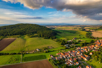 Vibrant German Village Nestled in a Valley Surrounded by Lush Greenery and Picturesque Mountains on a Bright Sunny Day
