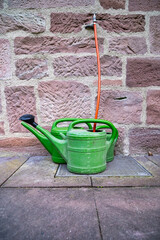 Plastic garden sprinklers standing against a stone wall. A country concept.