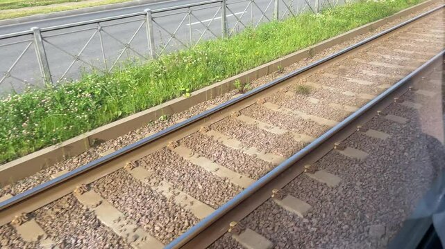 Train tracks run parallel to the highway, enveloped by lush green surroundings and natures beauty