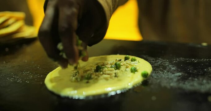 Indian caterers preparing fresh uttapam and crispy dosa on a hot tawa during a live food counter at a festive event